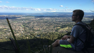 Male sitting on hill overlooking city of Wollongong